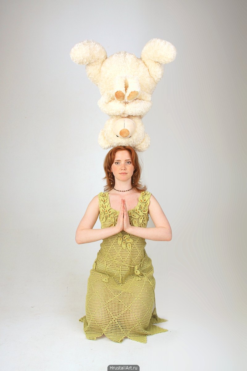Фотография, девушка стоит на коленях, руки сложены в молитвенный жест, на её голове покоится большой плюшевый медведь.
