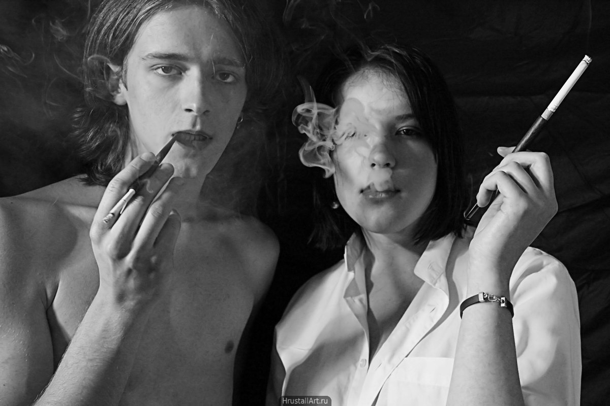 Фотография, вызывающе эротичные парень с девушкой курят из длинных мундштуков.