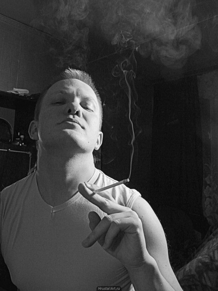 Портрет парня с сигаретой и тонкой струйкой дыма